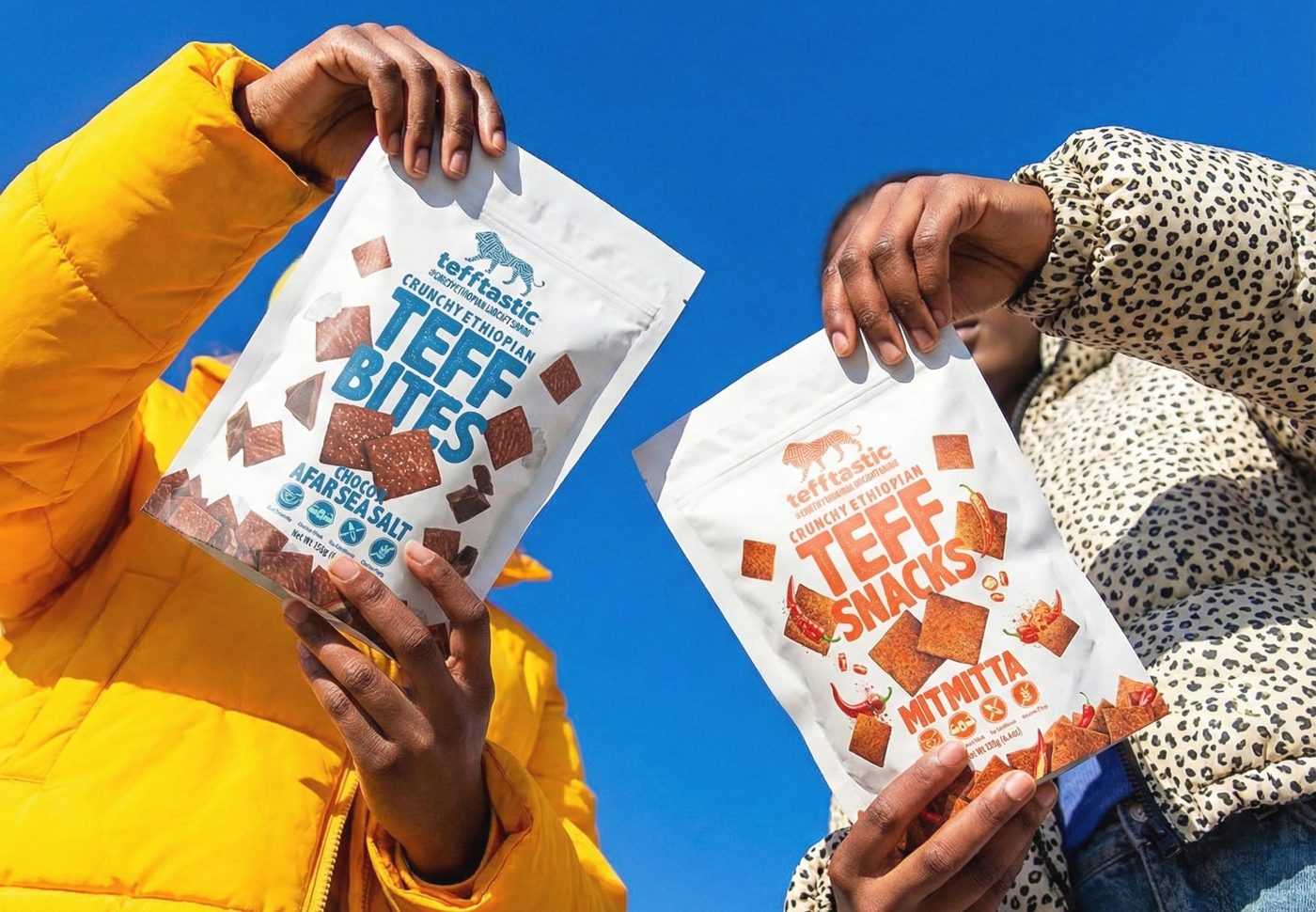Tefftastic teff bites held up against a blue sky